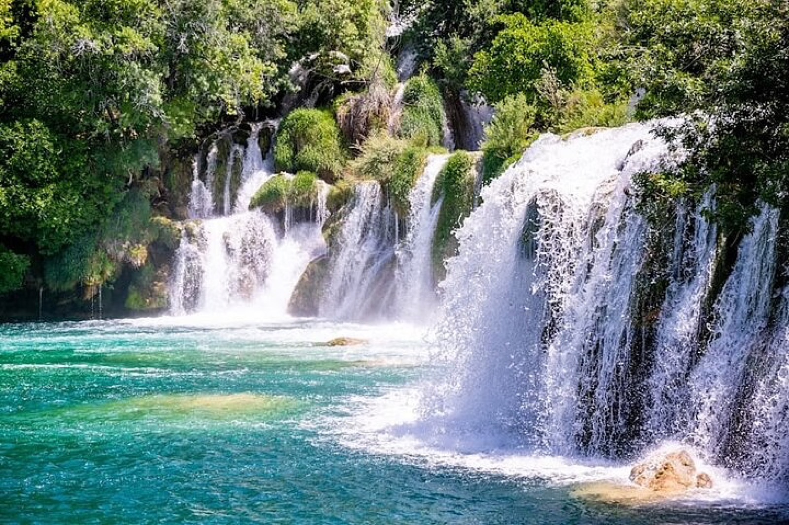 Turquoise cascades at Skradinski Buk in Krka National Park with the summer forest above
