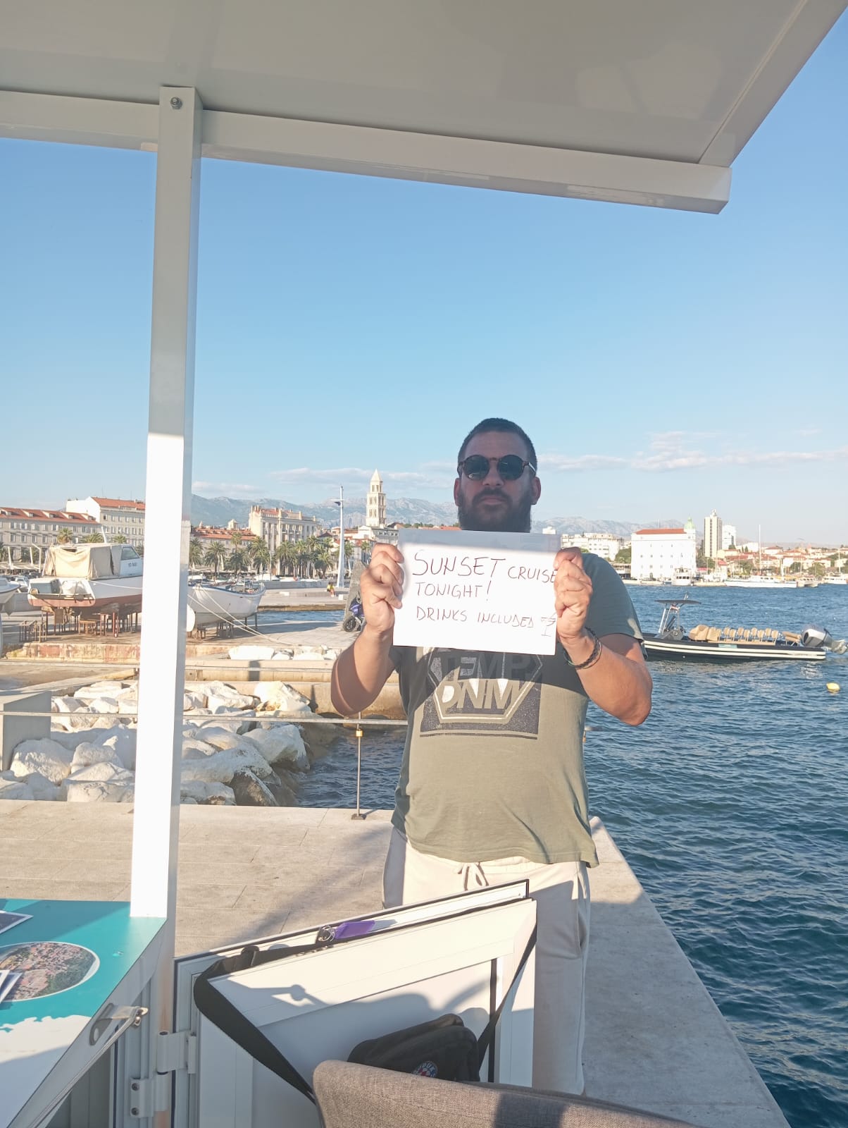 Silvio, licensed tour guide, on the Split Riva at sunset holding a cruise pickup sign